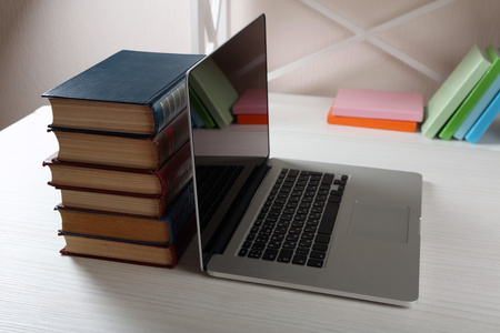 一摞书与笔记本电脑照片