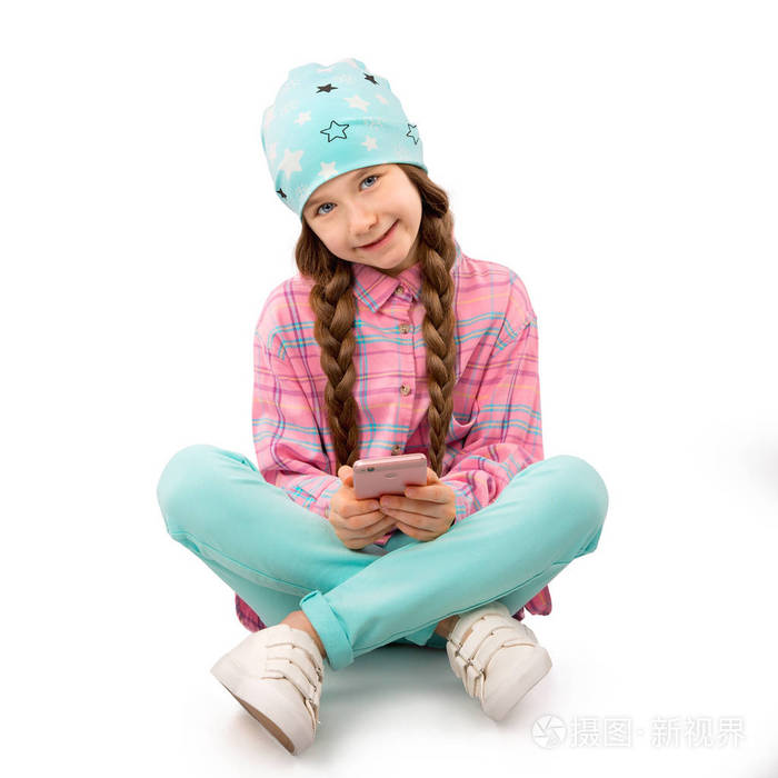 快乐的小女孩与智能手机坐在地板上孤立的白色背景人孩子技术概念