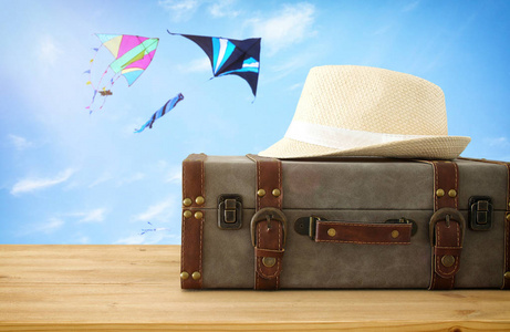 旅行者古董行李和软呢帽帽子在木桌。假日和假期概念