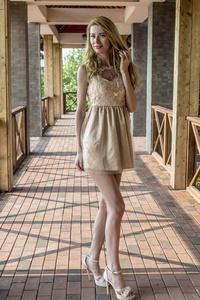 年轻漂亮的金发女郎穿着漂亮的连衣裙在夏日公园里