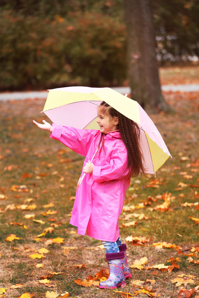 漂亮的小女孩在公园里的伞