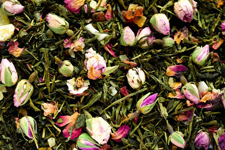 绿茶的质地与玫瑰花瓣。干燥的花蕾背景纹理特写。食物背景。有机健康草本叶, 排毒茶