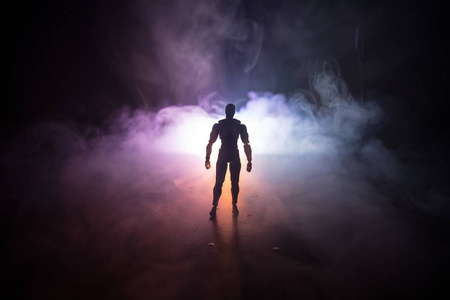 人的剪影站在一个黑暗的雾色调的背景。装饰照片与人图在桌与光