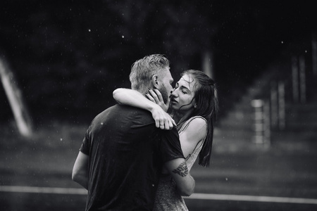 美丽的夫妇在雨中亲吻