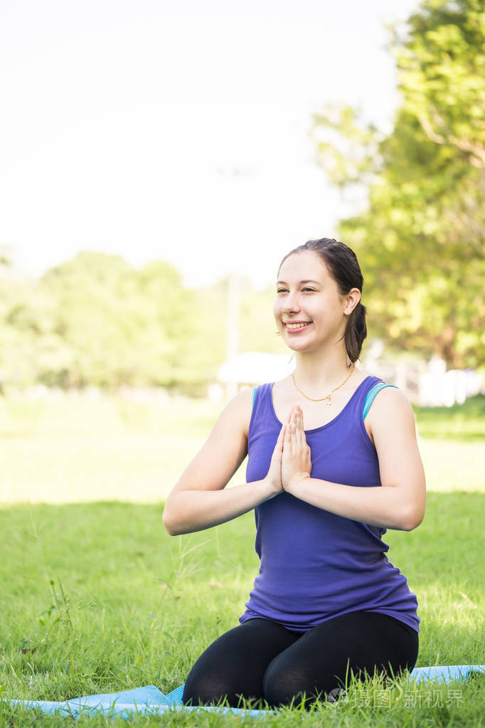 美丽的女人在公园做瑜伽练习健康生活方式概念
