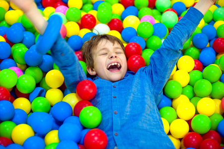 快乐的孩子小男孩玩在五颜六色的塑料彩球操场高视图。有趣的孩子在室内玩得开心