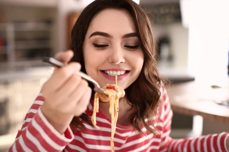 在家吃可口面食的年轻妇女