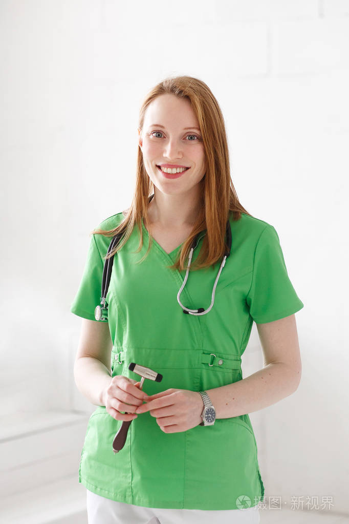 一个有魅力的年轻女医生神经学家的画像, 穿着绿色制服.