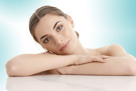 gorgerous 女人的肖像与完美的皮肤看着相机, 而躺在