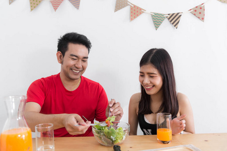 亚洲情侣用沙拉生活方式概念喂养对方