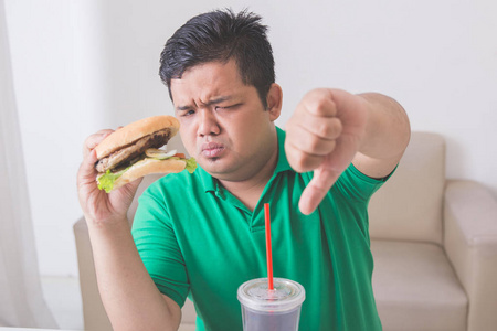 男人出现拇指下吃垃圾食品时