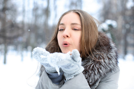 美丽的小女孩在公园里玩雪在寒假