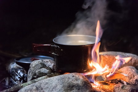 在现场条件下做饭，烧开水的壶在营火上野餐