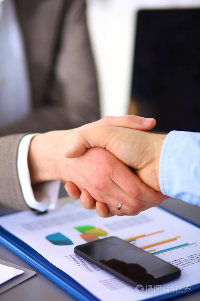 商务上的握手两个商人握手互相在办公室