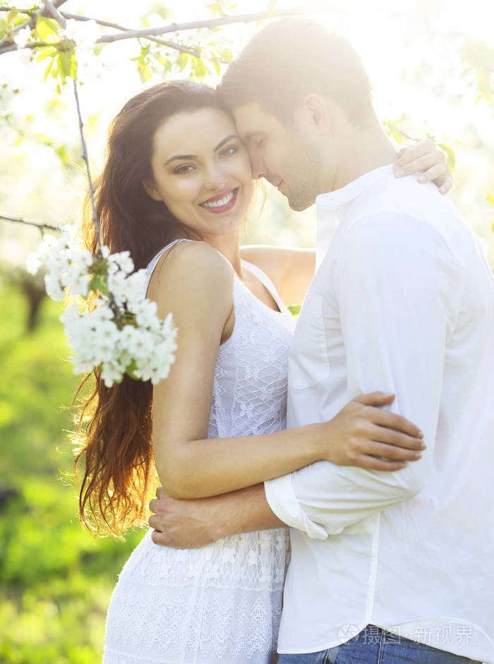 热恋中亲吻和拥抱春天公园里的情侣