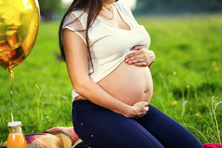 孕妇腹部的照片。手抱着孕妇的肚子。关闭人类的手拿着孕妇的肚子。怀孕的妇女抱着她的肚子。怀孕。怀孕的概念