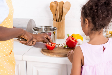 非洲裔美国人的母亲和女儿裁剪的看法在厨房切甜椒