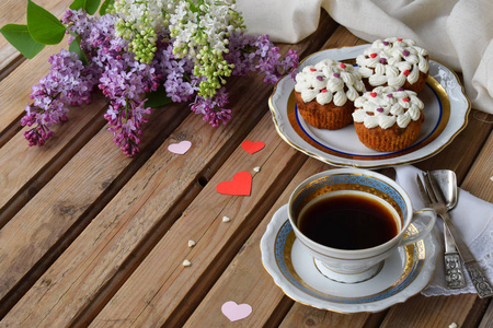 浪漫组成的花束白色和紫色的丁香花，豆腐奶油蛋糕杯咖啡上木制的背景。文本的空间