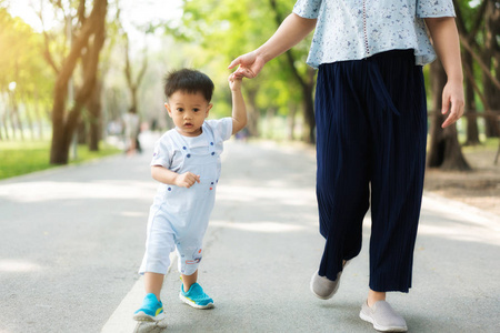 亚洲母亲在春天与孩子牵着手散步
