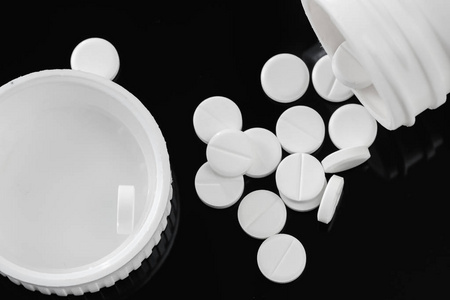 药片和瓶子是白色的.黑色隔离照片