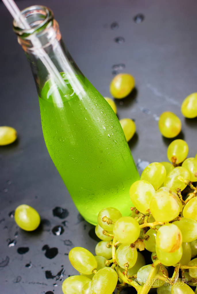 新鲜的绿色葡萄果汁瓶暗表