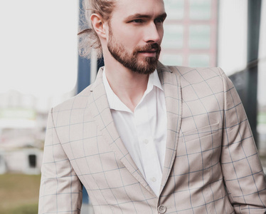 肖像的时尚帅气男模男人穿着优雅格子的套装户外摆上街头背景