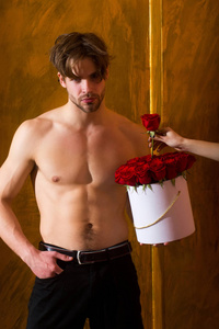 大胡子肌肉男与的身体拥有玫瑰的红盒子