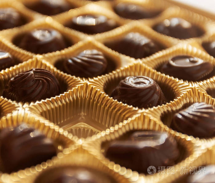 在一个金色的盒子，协调性的不同形状的巧克力糖果