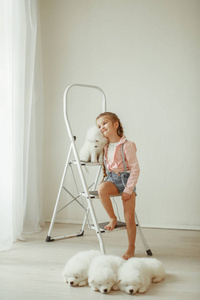 女孩摆着可爱的小狗, 坐在梯子上