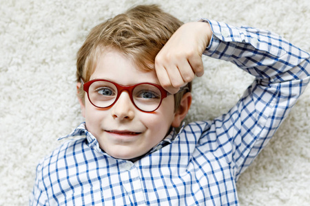 金发碧眼的孩子长着棕色眼镜小男孩的特写肖像