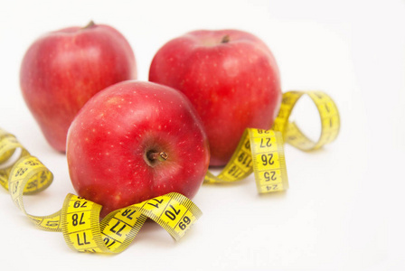 三红色苹果被隔绝在白色背景。脂肪燃烧和失重过程。卷尺。复制空间