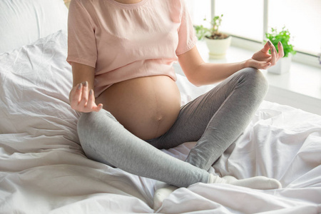 年轻的便溺女人怀孕了放松在室内的床上