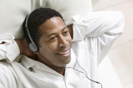 男人躺在沙发上听音乐用便携式cd播放器特写俯视图