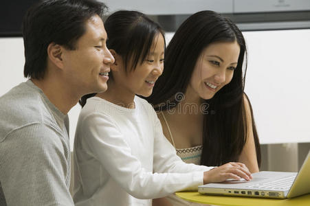 女儿和父母在客厅用笔记本电脑