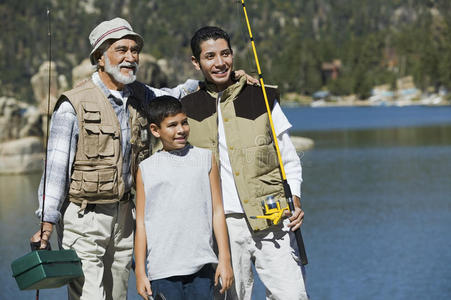 湖边拿着钓竿的爷爷和孙子