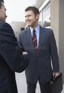商人在办公室外握手