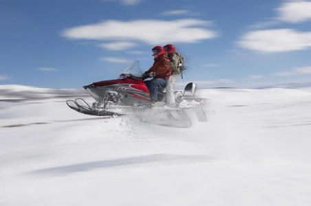 情侣在雪地里跳雪地车图片