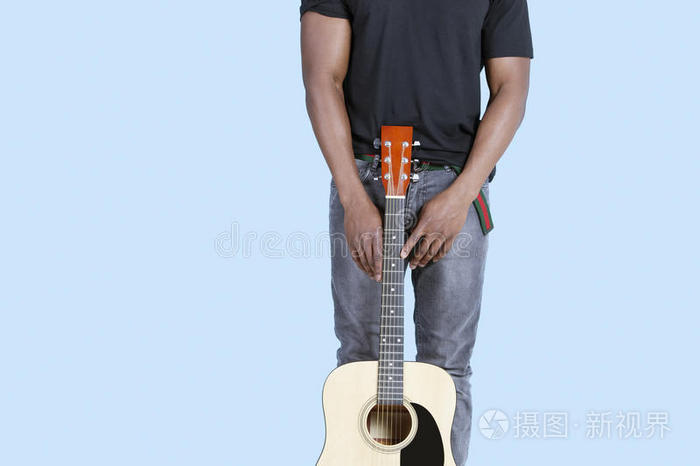 一位非洲裔美国男子的中段，浅蓝色背景上有吉他