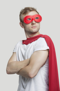 身穿红色超级英雄服装的年轻人抬头看向灰色背景