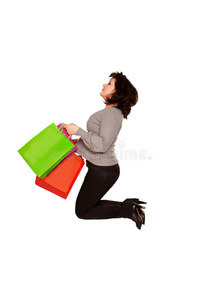 快乐的中年妇女拿着购物袋跳来跳去。