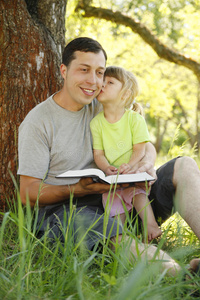 父亲带着他的小女儿读圣经