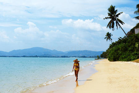 在泰国沙滩上散步的年轻女子