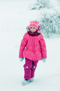 美丽快乐的女孩躺在雪地上