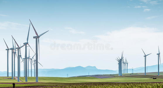 蓝天上绿野上的风力涡轮机。
