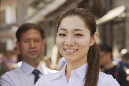 两位面带微笑的商界人士的画像，聚焦商界女性，户外，北京