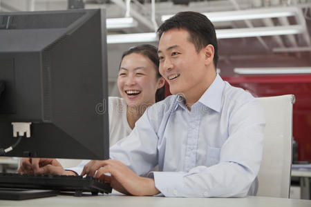 快乐的生意人在办公室里用电脑工作
