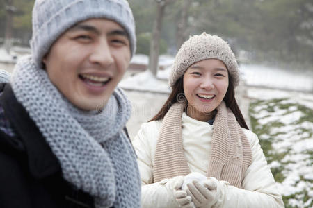 夫妻俩在雪地里玩，笑着