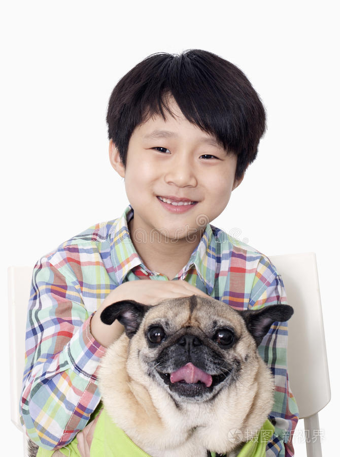 微笑的男孩抱着宠物哈巴狗的画像
