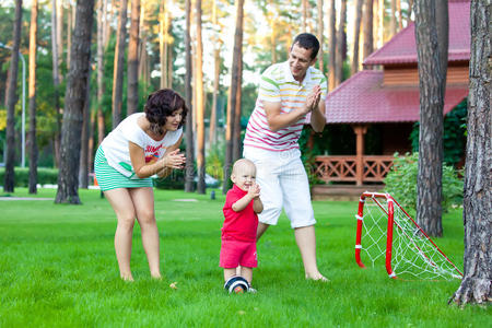 小男孩和父母一起踢足球