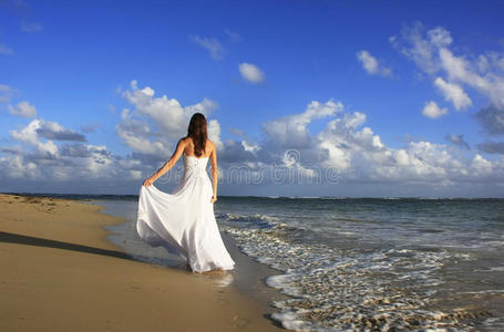海滩上穿白衣服的年轻女子照片
